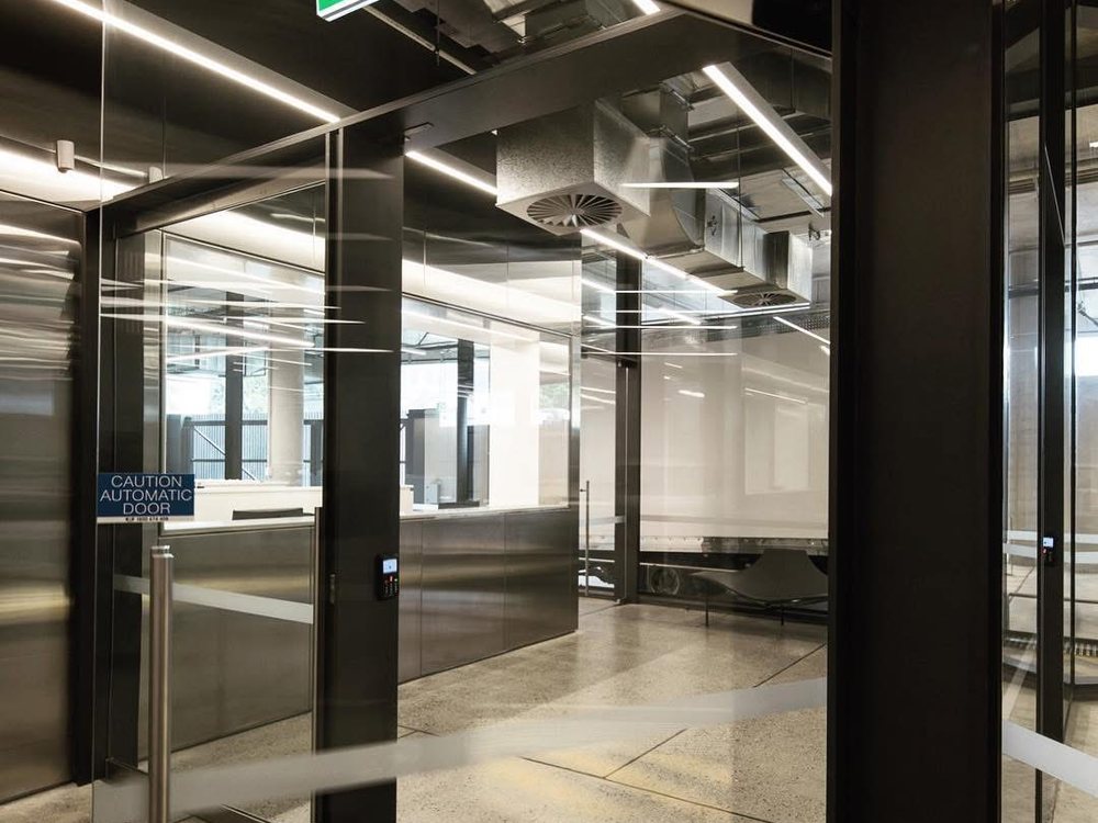 Automatic sliding doors with safety signage on a glazed entrance